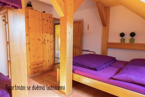 a bedroom with a bunk bed with purple sheets at Výprachtice L.V. in Výprachtice