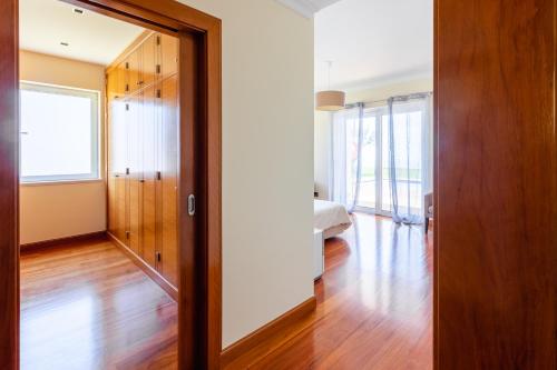 an empty room with a door and a hallway with wood floors at Bellevue Villa Madeira Magnificent Sea View in Prazeres