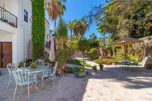 a patio with a table and chairs and an umbrella at Villas del Santo Niño in Loreto