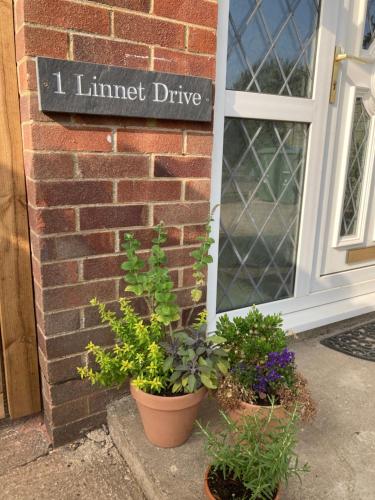 a sign on the side of a brick building with plants at Cheerful 3 bedroom property set in the countryside in Westcott