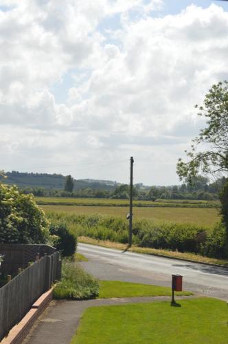 a road with a fence next to a field at Cheerful 3 bedroom property set in the countryside in Westcott