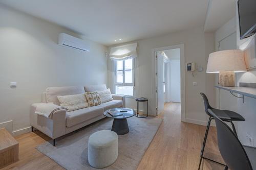 salon z kanapą i stołem w obiekcie Apartment in the Heart of the Historic Center w Maladze