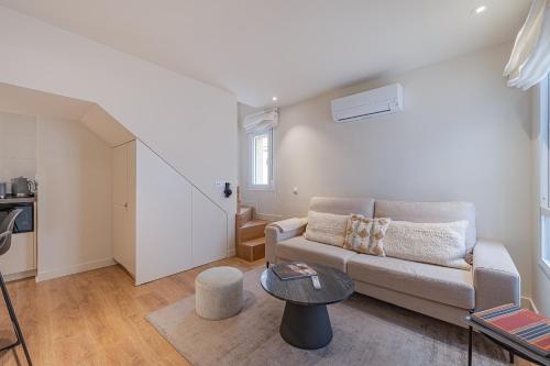 salon z kanapą i stołem w obiekcie Apartment in the Heart of the Historic Center w Maladze