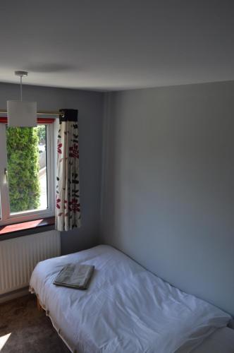a bed in a bedroom with a window at Cheerful 3 bedroom property set in the countryside in Westcott