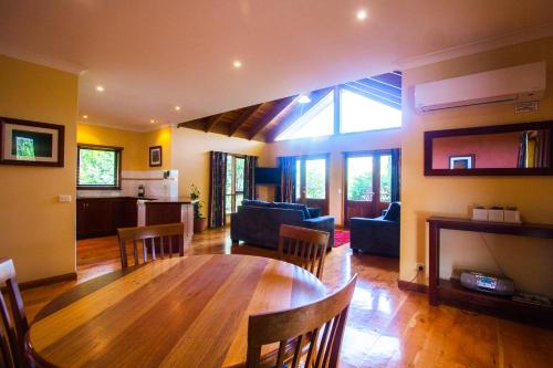 a living room with a wooden table and a kitchen at Perricoota Vines Retreat in Moama