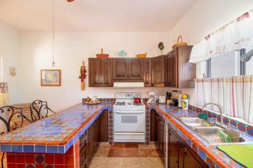 a kitchen with wooden cabinets and a white stove top oven at Villas del Santo Niño in Loreto