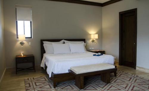 1 dormitorio con 1 cama blanca grande y 2 mesas en Paseo Suites El Valle, Luxury Apartments, en El Valle de Antón