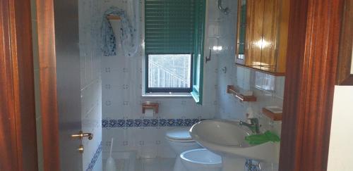 a bathroom with a sink and a toilet and a window at Villa dei Focesi in Ascea