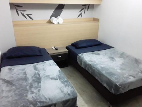 een slaapkamer met 2 bedden en een tafel en een plank bij Primavera Hotel in Medellín