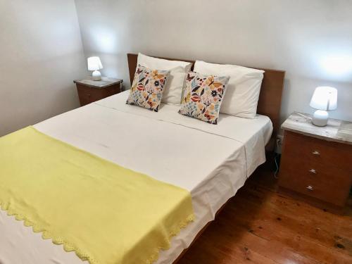 a bedroom with a large white bed with two pillows at Sublime Yellow Bedroom in Lisbon