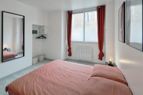 1 dormitorio con 1 cama grande y espejo en T2 RIEFFEL - Centre-ville - Wifi, en Nozay