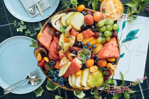 a plate of fruit and vegetables on a table at La Fleur Boutique Hotel in Tivat