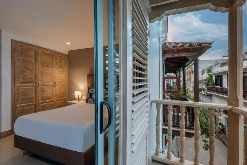 um quarto com uma cama e uma varanda em Apartamentos casa Gimani em Cartagena das Índias