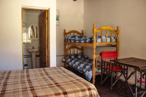 a bedroom with a bed and a table and a bunk bed at Altas Cumbres Penitentes in Los Penitentes