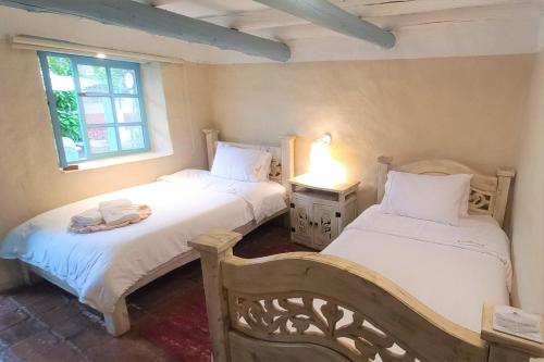 a bedroom with two beds and a window at Casa Provenzal in Villa de Leyva