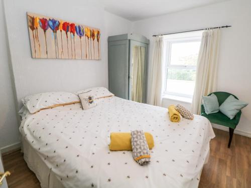 Un dormitorio con una cama blanca con almohadas. en Beas Cottage, en Highpeak Junction