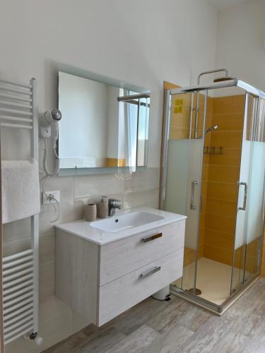 een badkamer met een witte wastafel en een douche bij Maison Merci in Pedemonte