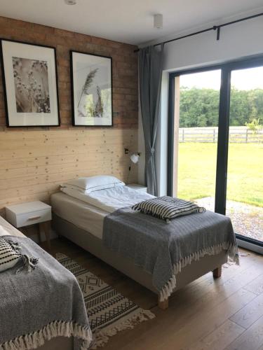 a bedroom with a bed and a large window at Calma House Ublik in Wyszowate