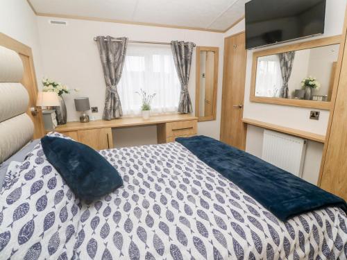 a bedroom with a bed with a blue pillow on it at Chantry Lodge in Newquay