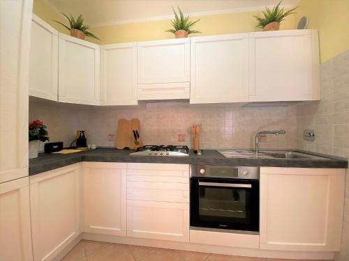 a kitchen with white cabinets and a sink at Residenza Airone Bianco in Ronchi dei Legionari