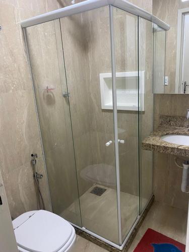 a bathroom with a shower with a toilet and a sink at Flat Bervely Hills 308 in Vila Velha