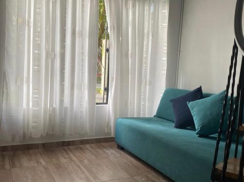 a blue couch in a room with a window at Pequeño Paraíso 2 in El Placer