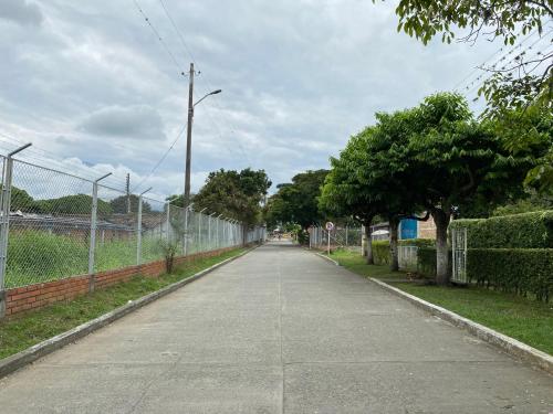 an empty street next to a fence and trees at Pequeño Paraíso 2 in El Placer