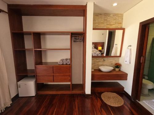 a bathroom with a closet with a sink and a mirror at Hotel Vila Marola in Taíba