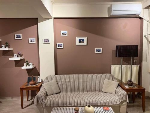 a living room with a couch and a wall with pictures at Rania's house in Thessaloniki