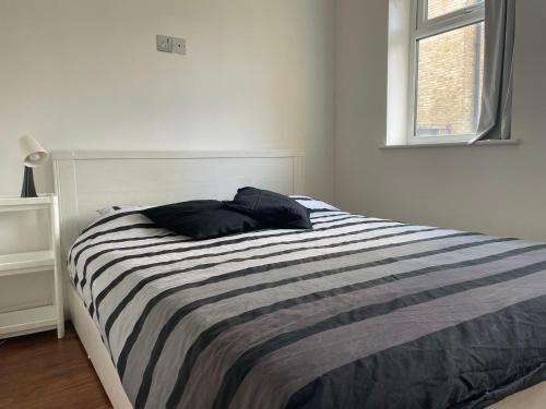 a bedroom with a bed with a striped blanket at Bethnal Cove in London