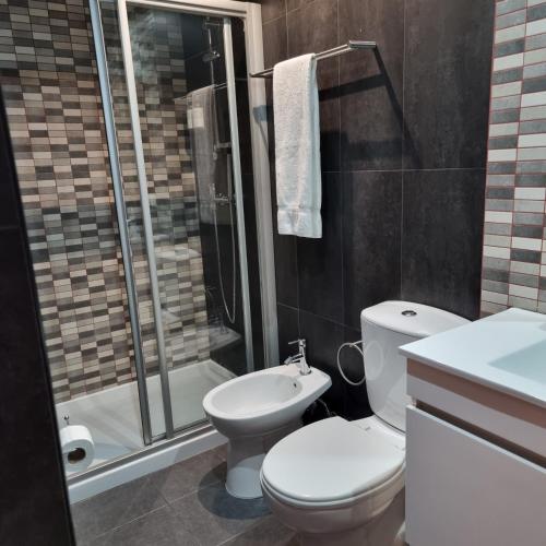 a bathroom with a toilet and a shower at Casa Dos Cedros in Lagos
