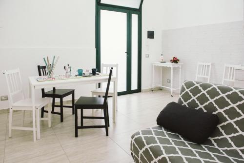 een woonkamer met een bank en een tafel met stoelen bij Casa Grazia Guest House in Aci Castello