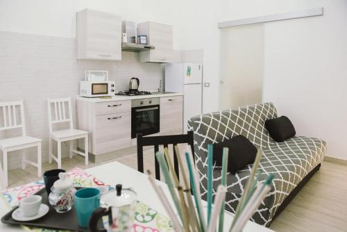 een keuken en een woonkamer met een bank en een tafel bij Casa Grazia Guest House in Aci Castello