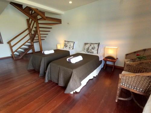 a room with two beds and a staircase at Hotel Vila Marola in Taíba