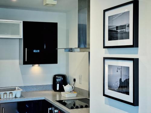 a kitchen with black and white pictures on the wall at Artistic and luxurious APT with Sea view. Beach side in Swansea