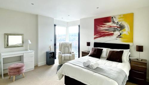 a bedroom with a bed and a painting on the wall at Artistic and luxurious APT with Sea view. Beach side in Swansea