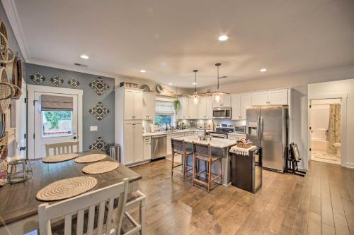 a kitchen with white cabinets and a table with chairs at 2 Mi to Downtown Luxe Greenville Retreat! in Greenville