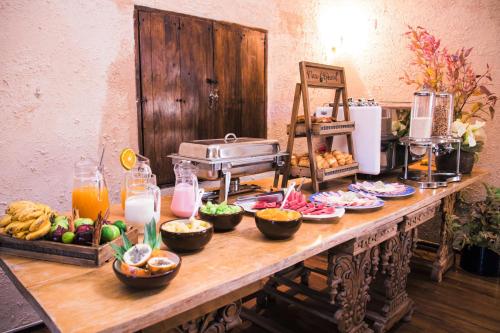 a table topped with plates of food and bowls of fruit at Tambo del Arriero Hotel Boutique in Cusco