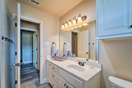 a white bathroom with a sink and a mirror at Quaint Lubbock Home about 6 Mi to TTU and Downtown! in Lubbock