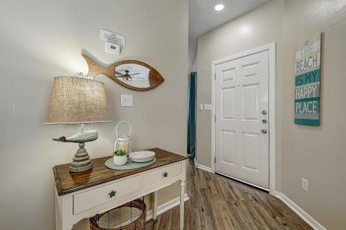 a room with a table with a lamp and a door at Leeward Isles 207 in Padre Island