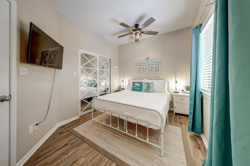 a bedroom with a bed and a ceiling fan at Leeward Isles 207 in Padre Island