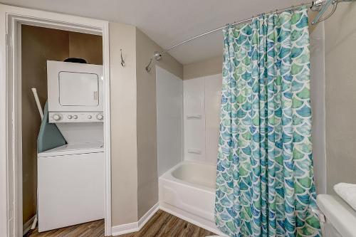a bathroom with a shower curtain and a tub at Leeward Isles 207 in Padre Island