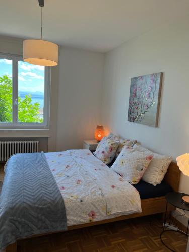a bedroom with a bed and two windows at Alpes Rez in Neuchâtel