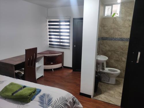 a bathroom with a bed and a sink and a toilet at Zidko Guest House in Ibarra