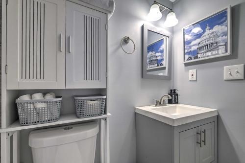 a white bathroom with a sink and a toilet at Modern DC Apartment about 6 Mi to National Mall! in Washington, D.C.