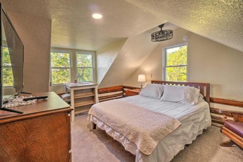 a bedroom with a bed and a desk and windows at Pet-Friendly Speedwell Cabin, 1 Mi to Water! in Alder