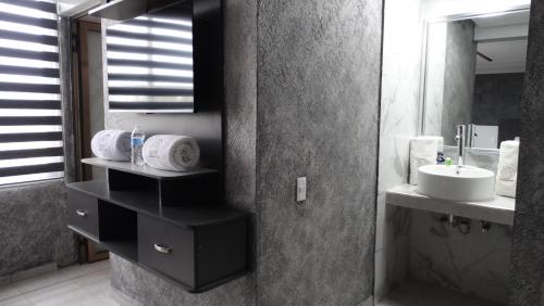 a bathroom with a sink and a mirror at MOTEL & HOTEL ALJIBE in Ranchito