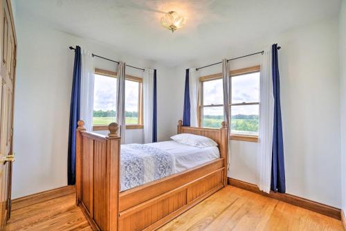 a bedroom with a bed and two windows at McArthur Cabin Peaceful Getaway on Farm! in Stella