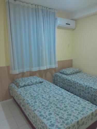 Tempat tidur dalam kamar di APARTAMENTO ACONCHEGANTE PROXIMO A PRAIA DO ARACAGY