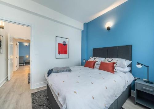 - une chambre bleue avec un grand lit et des oreillers rouges dans l'établissement 2 Bedroom - Tower Bridge - London City by Prime London Stays M-11, à Londres
